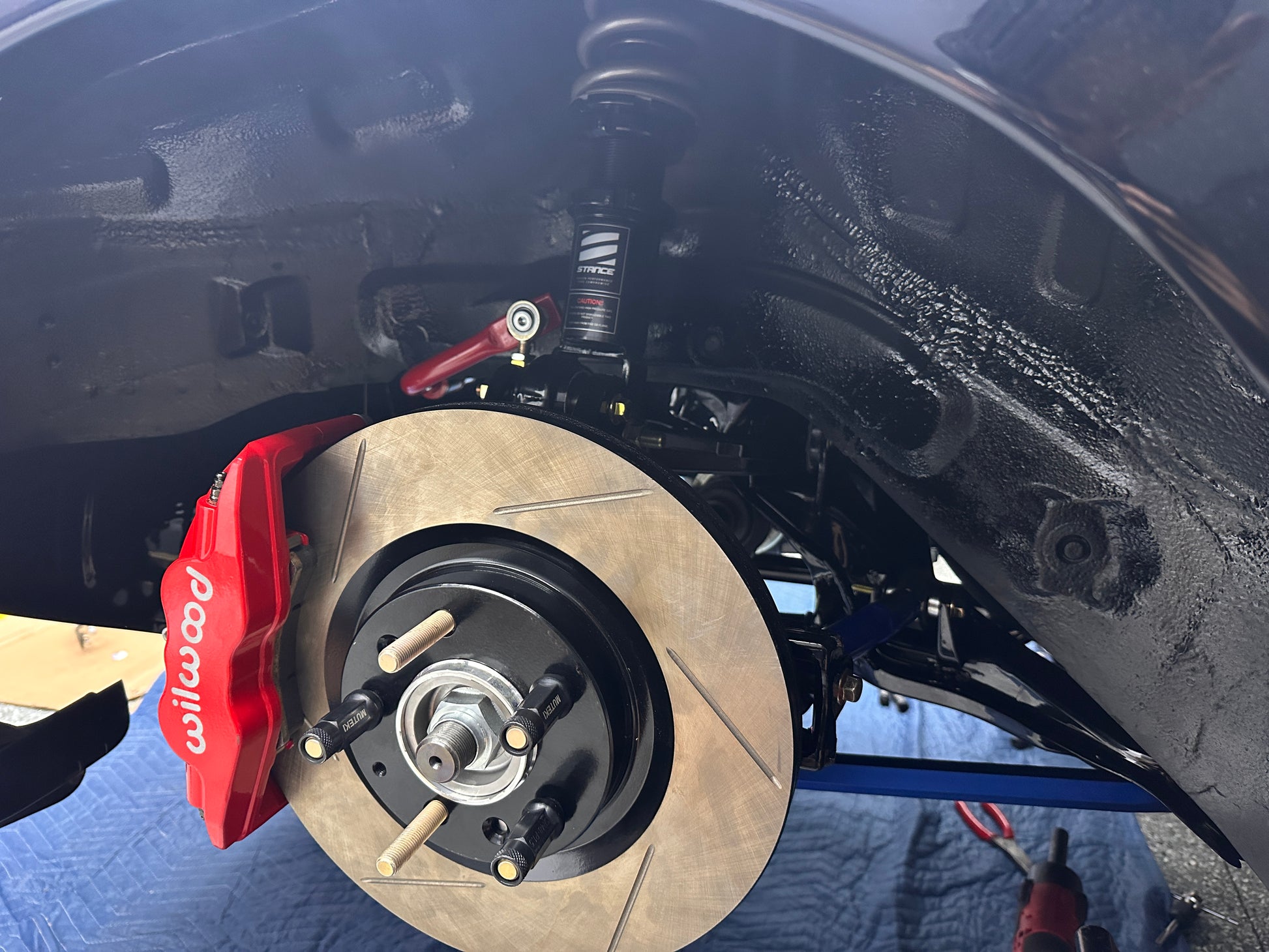 Close-up of FD3S RX-7 rear Wilwood Superlite caliper mounted with RX-8 Sport rear rotor